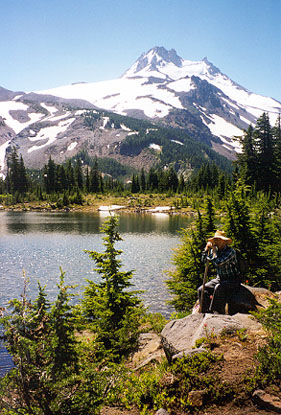 Chris Maser sitting in front of a Mountain